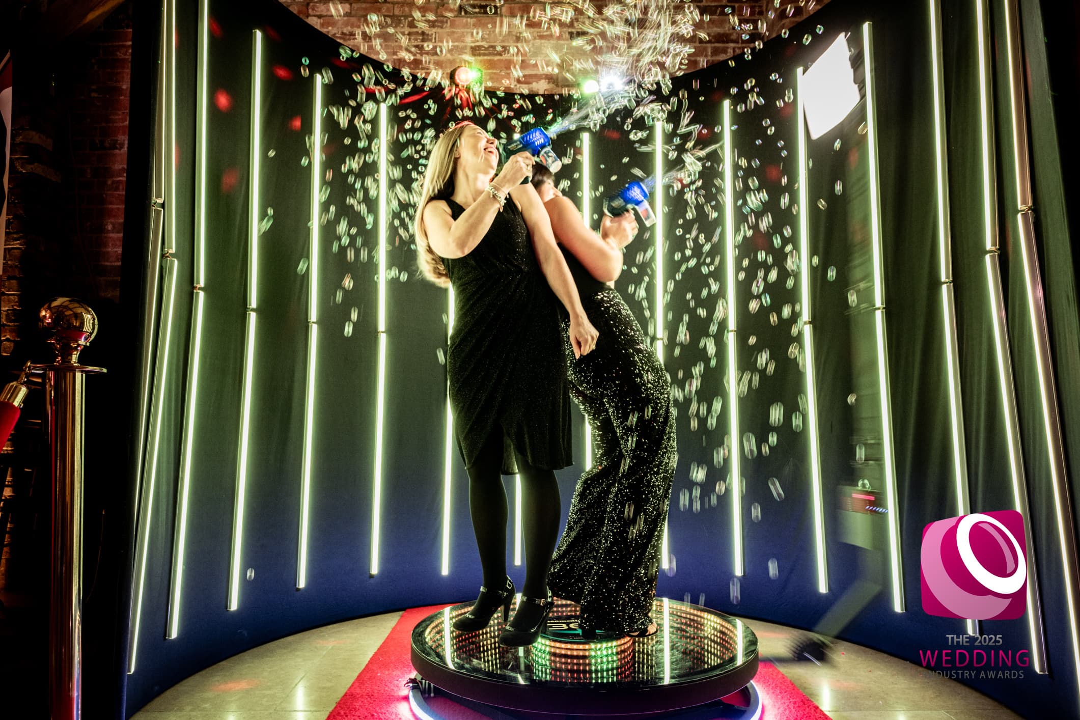 Guests posing with confetti on a 360 photo booth at a celebration