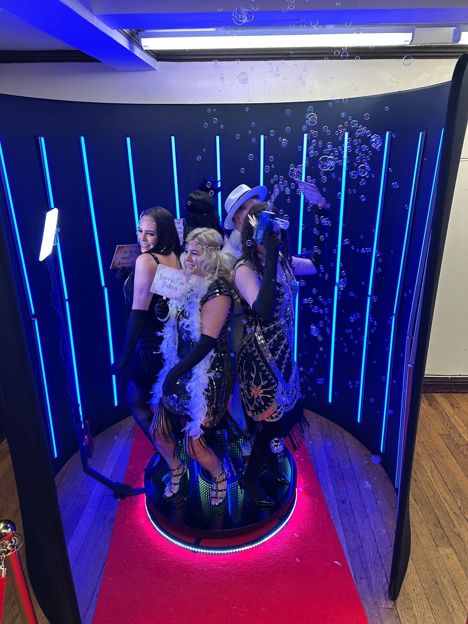 Group of guests on a 360 photo booth with RGB lighting backdrop